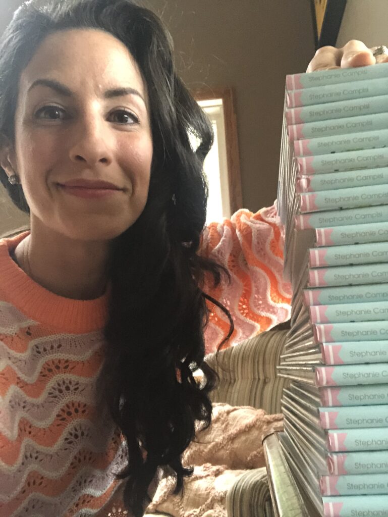 Image of author Stephanie Campisi by a stack of books