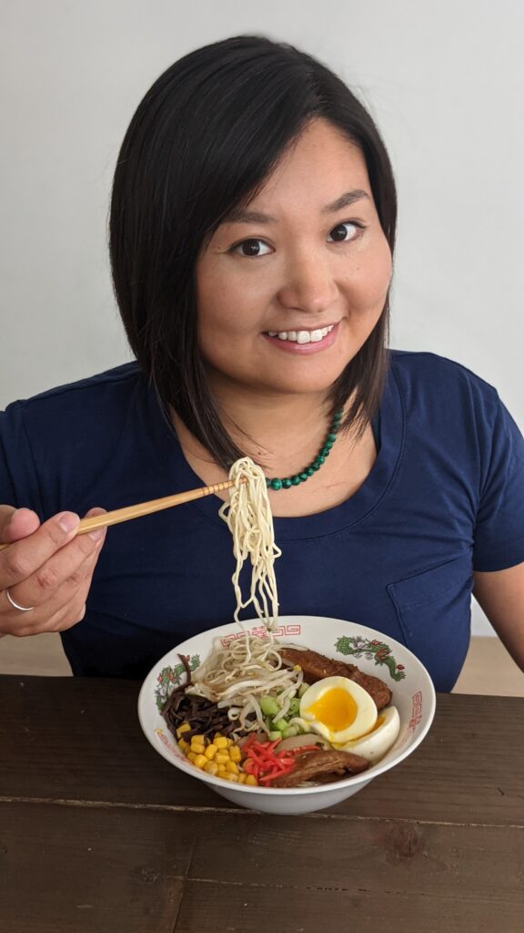 Image of author/illustrator Shiho Pate sitting at a table eating a bowl of ramen